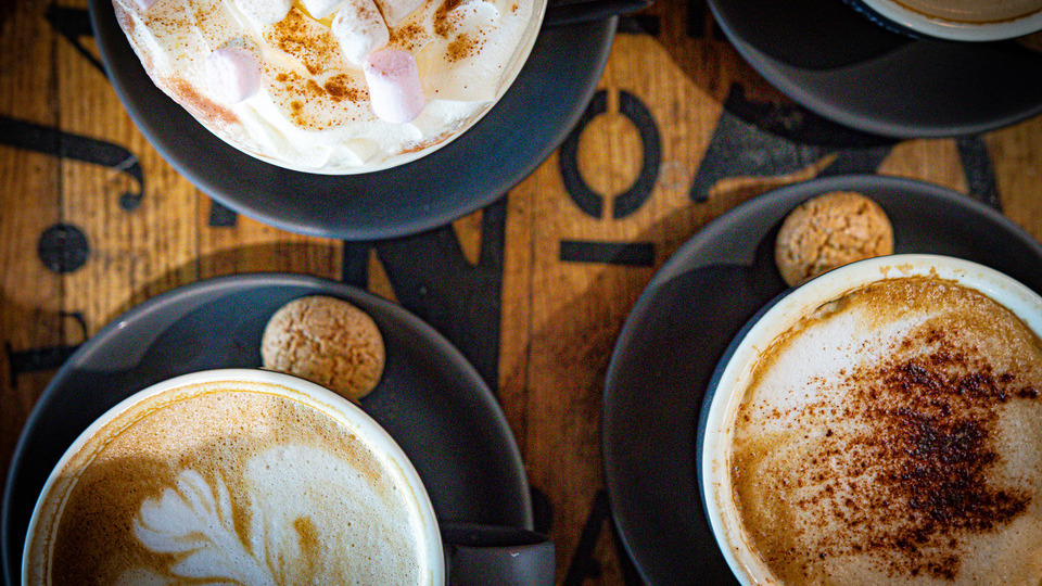 three lattes on black saucers